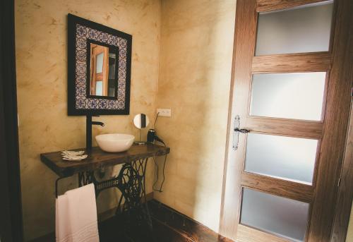 a bathroom with a door and a sink at Hotel Rural La Guaja in Puebla de Sanabria