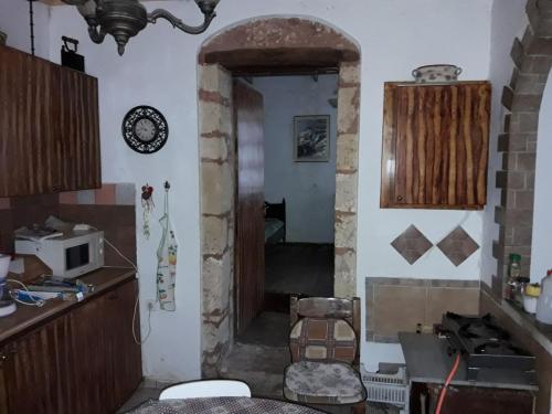 a kitchen with a door to a kitchen with a microwave at VLASSIS APTS -ΜΕΛΙΔΟΝΙ-ΔΙΑΜΕΡΙΣΜΑ ΒΑΣΙΛΙΚΗ in Melidhónion