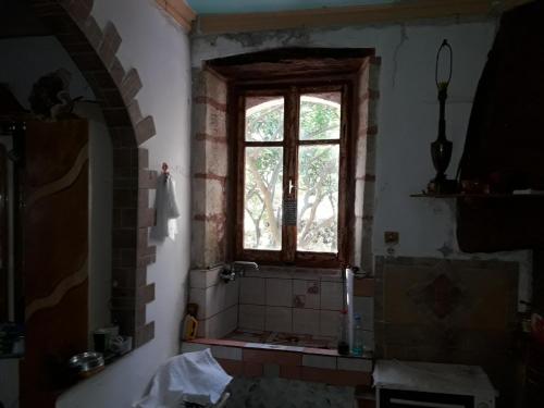 a bathroom with a window and a tiled shower at VLASSIS APTS -ΜΕΛΙΔΟΝΙ-ΔΙΑΜΕΡΙΣΜΑ ΒΑΣΙΛΙΚΗ in Melidhónion