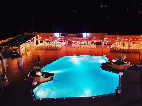 an overhead view of a large swimming pool at night at Hotel Certosa in Padula