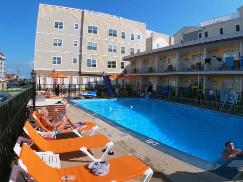uma piscina num hotel com pessoas sentadas em cadeiras de jardim em Sea Chest Motel Dot Com for Deals! em Wildwood Crest