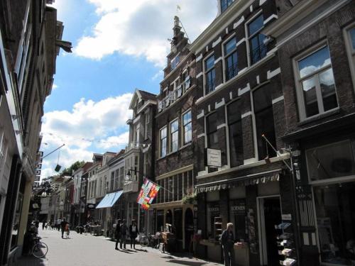 a city street with buildings and people walking down a street at Hanzestadslogement "De Leeuw", logies in het centrum van Deventer in Deventer