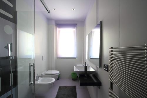 a white bathroom with a sink and a toilet at Il Ruscello Rooms and Luxury Suite in Roccaraso