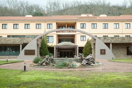 a building with a sculpture in front of it at Hotel Balneario Valle del Jerte in Valdastillas