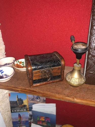 a shelf with a wooden box and a bell on it at Aleen Guest House in Nazareth