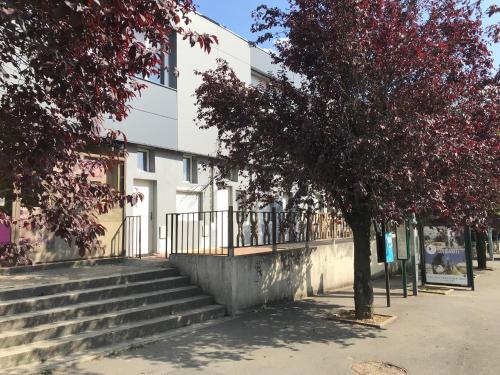 a building with stairs and a tree in front of it at Chez Nahiko STUDIO Paris Massy Palaiseau in Palaiseau