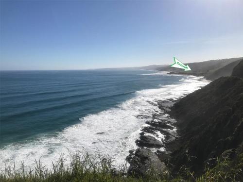 a kite flying over the ocean on a cliff at Seacroft Estate in Apollo Bay