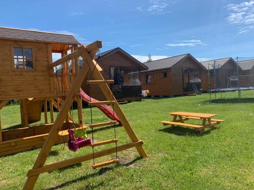 a playground with a slide and a picnic table at Domki Nadmorskie Wicie in Wicie