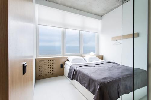 a bedroom with a bed and a glass wall at Sea & Sky apartments in Odesa