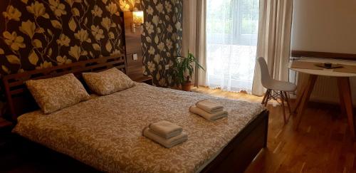 a bedroom with a bed with two towels on it at UKI-Modern apartment with parking in Novi Sad