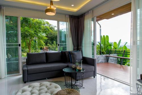 a living room with a couch and a table at Ao Luek Panoramic Pool-SHA Plus in Ao Luk