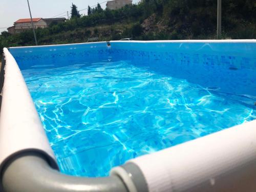 a swimming pool with blue water in it at Rosi`s Apartment in Sutomore