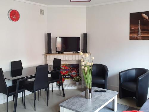 comedor con mesa, sillas y TV en Appartement des Remparts, en Valenciennes