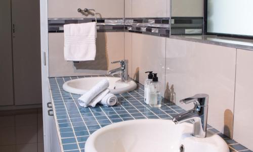 a bathroom with two sinks and a bath tub at Tsitsikhaya Lodge in Stormsrivier
