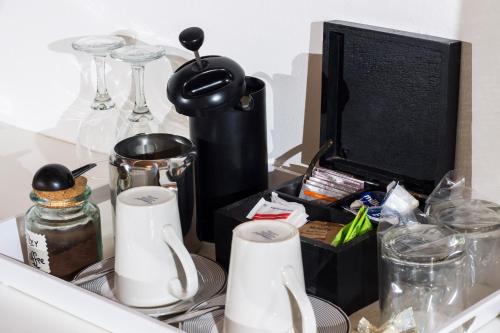a drawer filled with dishes and cups and a tv at Tsitsikhaya Lodge in Stormsrivier