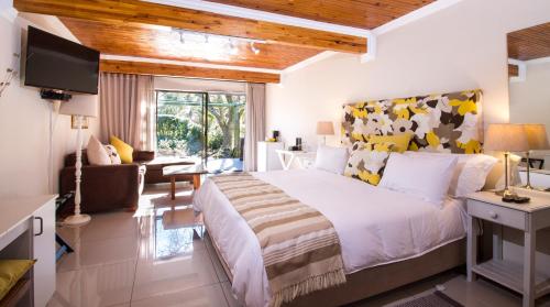 a bedroom with a large bed and a living room at Tsitsikhaya Lodge in Stormsrivier