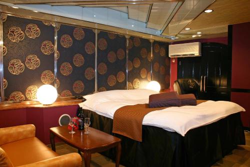 a room with two beds and a chair at Hotel Chapel Story Sakai in Sakai