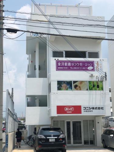 a white building with a sign on it at A&B Omoromachi Station in Naha