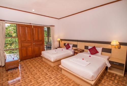 a hotel room with two beds and a window at Puri Saron Hotel Madangan - Gianyar in Gianyar