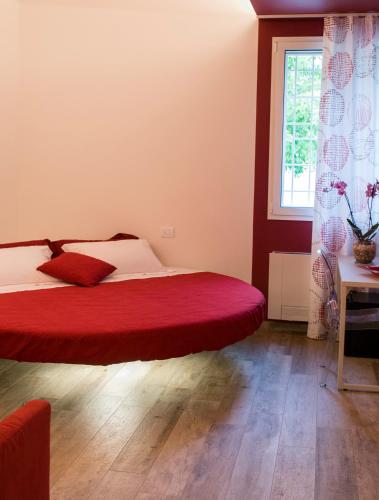 a bedroom with a large bed with a red blanket at Agriturismo N'Uova Campagna in Bologna