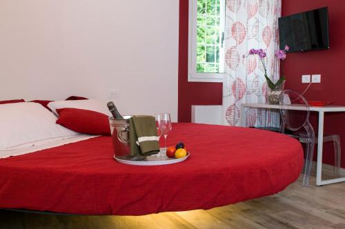 a room with a red bed with a table with a blender and fruit at Agriturismo N'Uova Campagna in Bologna