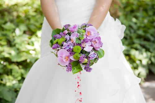 a bride holding a bouquet of purple and white flowers at Hotel Balneario Valle del Jerte in Valdastillas