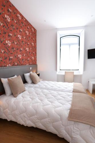 a bedroom with a large white bed and a window at Glass Boutique - Rooms & Suites in Marinha Grande