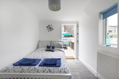 a bedroom with a bed with blue pillows on it at Cultural heart of Margate in Margate
