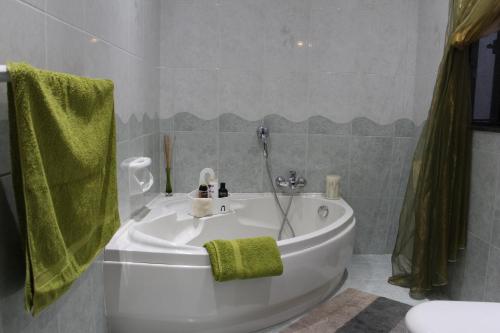 a bathroom with a white tub and a green towel at Cosy Home in Mellieħa