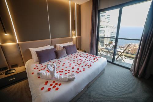 una habitación de hotel con una cama con flores rojas. en Rawsheh 51 en Beirut
