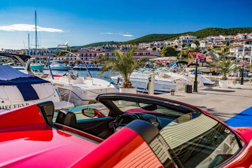 a car parked next to boats in a marina at Delfin Port Apartments - Prime Location & Parking & Pet Friendly in Sveti Vlas
