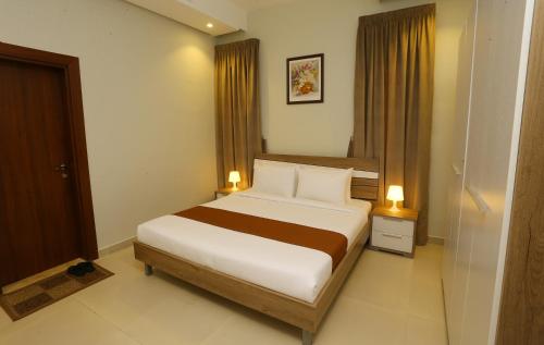 A bed or beds in a room at Grand Dahlia Hotel Apartment - Sabah Al Salem