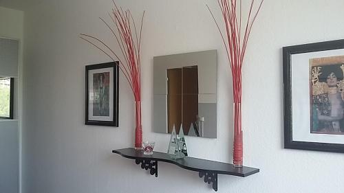 a mirror on a wall with red vases on it at Am Goldenen Reiter in Dresden