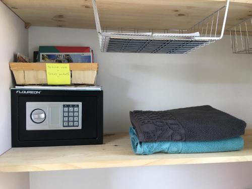 eine Mikrowelle auf einem Regal in einem Raum in der Unterkunft PETIT STUDIO de L'ERMITAGE in Gujan-Mestras