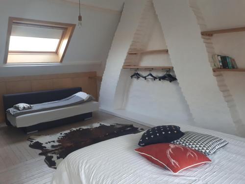 een slaapkamer op zolder met een bed en een raam bij Huize Hertog in Brugge