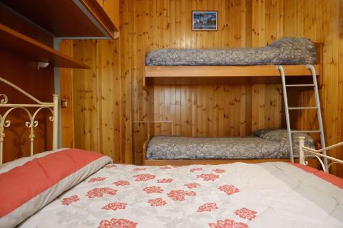 a bedroom with two bunk beds in a wooden wall at Casale dell'Arvo in Lorica