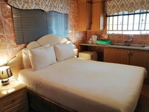 a bedroom with a large bed in a kitchen at Lenasia Guest Lodge in Lenasia