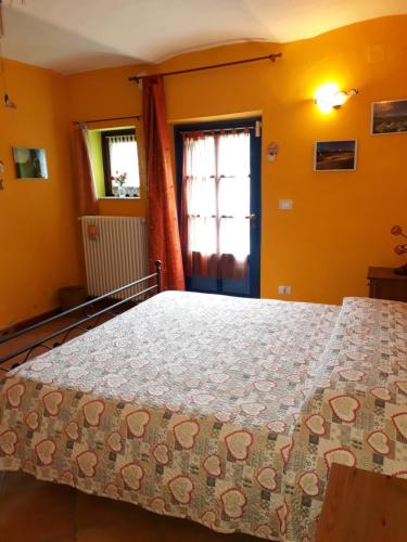 a bedroom with a bed in a room with yellow walls at B&B Locanda della Sesta Felicità in Vaglio Serra