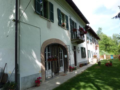 a white building with a gate and flowers in a yard at B&B Locanda della Sesta Felicità in Vaglio Serra