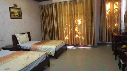 a hotel room with two beds and a desk at Hai Duong Guesthouse in Hòa Bình