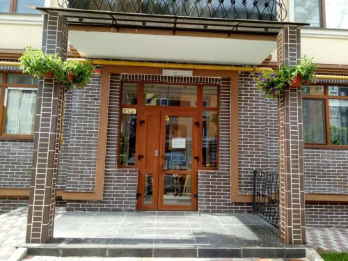 a brick building with a wooden door and flowers at Apartment Studio New York 51 in Irpin'