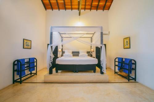 ein Schlafzimmer mit einem Himmelbett in der Unterkunft Villananda in Ambalangoda