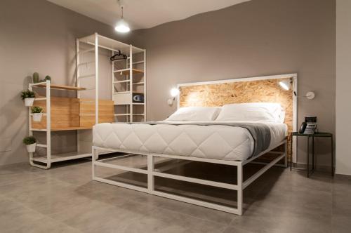 Residence Hotel Moderno في باري: غرفة نوم مع سرير أبيض كبير ورفوف
