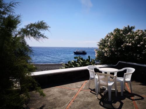 a table and chairs on a patio overlooking the ocean at Villa Mareblu Luxury Holiday Apartment direttamente sul mare in Stromboli