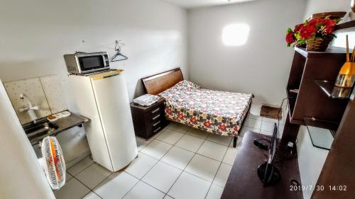 a small kitchen with a refrigerator and a chair at Flat Três Marias in Goiânia