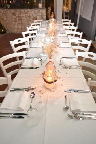 a long table with white plates and silverware on it at Agriturismo Giorgio in Mattinata