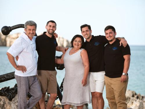 a group of people standing next to the water at Nobelos Seaside Lodge in Agios Nikolaos
