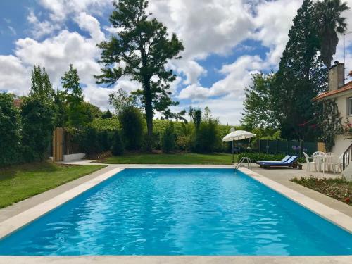 a swimming pool in the yard of a house at Quinta dos Capuchos Casa da Adega in Alcobaça