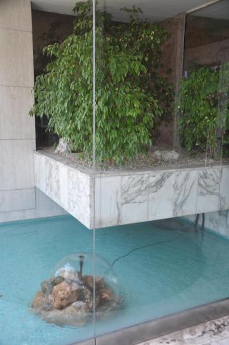 une fontaine dans une piscine dans un bâtiment dans l'établissement STUDIO PROMENADE FLORIDA BEACH, à Nice