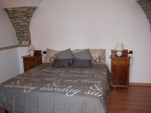 - une chambre avec un lit et 2 tables de chevet dans l'établissement APPARTAMENTO AURORA Val di Sogno, à Malcesine